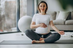 Yoga prenatal | Mujer embarazada haciendo yoga en casa